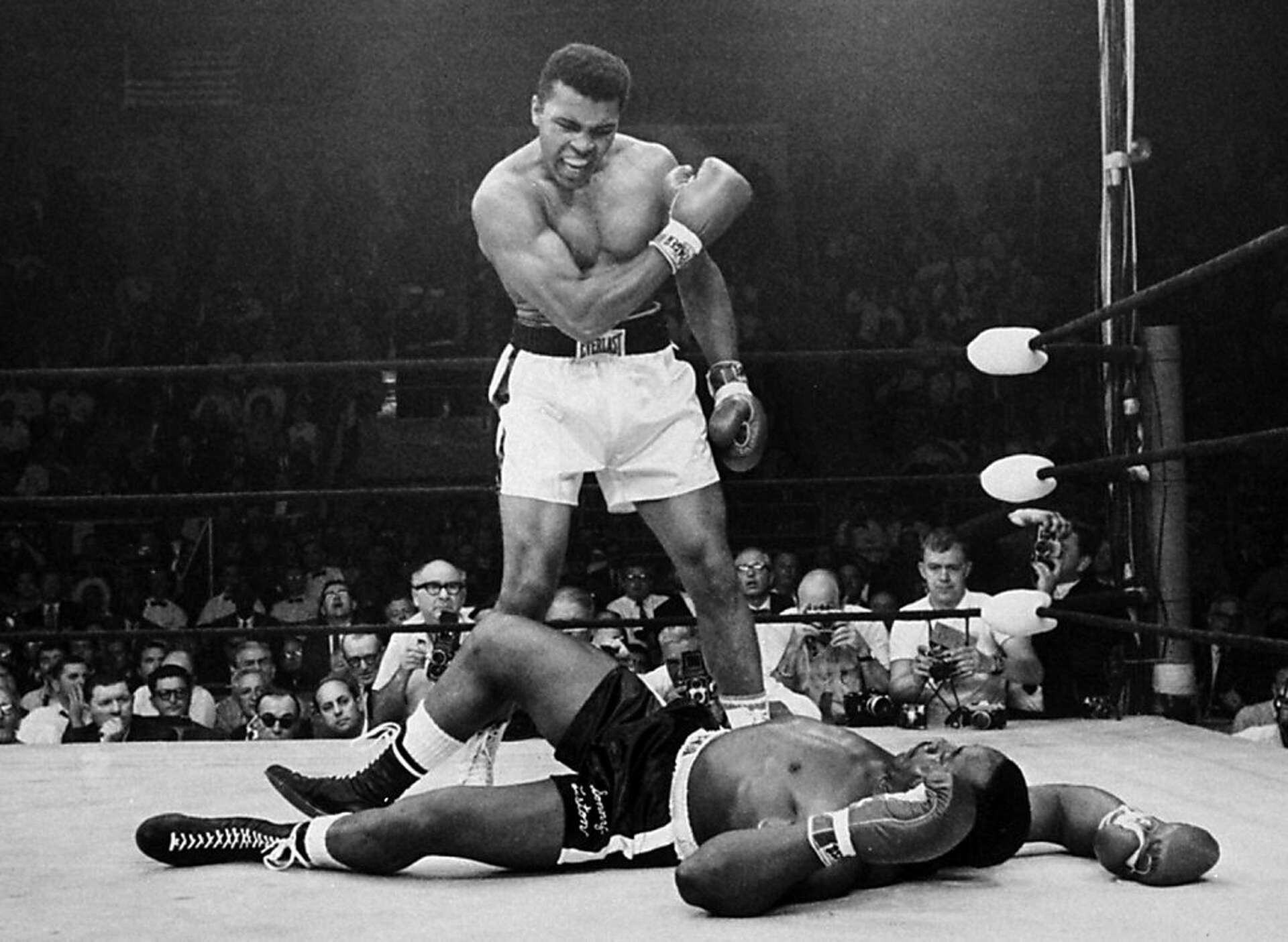 Muhammad Ali standing over a fallen Sonny Liston, fist cocked, taunting him to get up